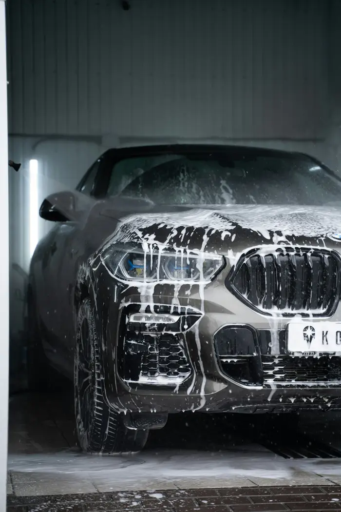 A car covered in soap suds during a hand wash