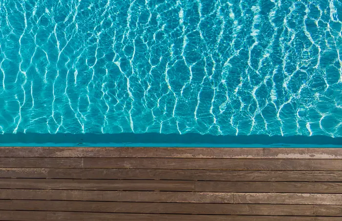 Clear pool water beside a wooden deck